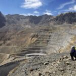 Industria Minera en chile. Imagen muestra mina abierta con dos trabajadores en la cima