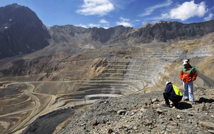 Industria Minera en chile. Imagen muestra mina abierta con dos trabajadores en la cima